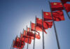 China’s Quiet Power Play Near Manila Multiple Chinese flags waving against a clear blue sky