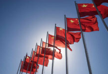 China’s Quiet Power Play Near Manila Multiple Chinese flags waving against a clear blue sky