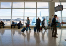 Airport Scale Shock: The 32kg Hard Stop Passengers in an airport terminal with luggage and an airplane visible outside