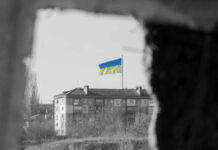 Congress Advances Billions More for Ukraine Ukrainian flag over apartment building seen through a dark frame