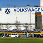 Volkswagen factory exterior with new cars on transport racks