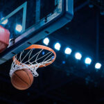 Congress Turns Heat On WNBA Basketball swishing through hoop under arena lights