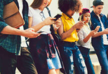 Backdoor Vote Revives EU Chat Scans Group of young people looking at smartphones