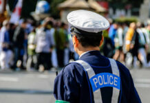 Horrifying Lip-Stitch Mystery Grips Japan Police officer monitoring a crowd at an outdoor event