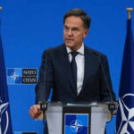 NATO’s Quiet Nuke Move—What’s Really Changing? Man speaking at podium with NATO flags behind him