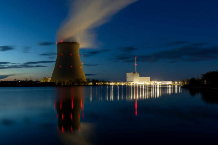 nuclear-power-plant2288146041jpg Cooling tower of a power plant at night beside a calm river