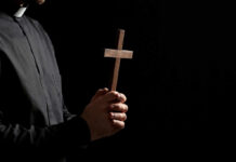 Clergyperson holding a wooden cross