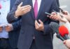 Rental Truck? Texas Senate Ad Backfires Businessperson in suit speaking to reporters with microphones