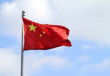 China’s Flying Van-Plane Lands In Europe Chinese national flag waving on a flagpole