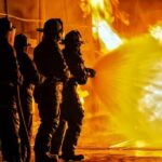 Wind-Whipped Blaze Guts Neighborhood Firefighters battling a large blaze with a hose