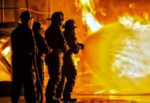 Wind-Whipped Blaze Guts Neighborhood Firefighters battling a large blaze with a hose