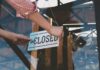Mock Mass Backfires — Club Shuttered Fast Hands hanging a closed sign on a glass door