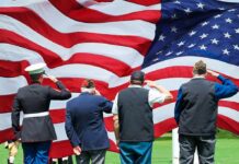 Overlooked VA Benefit Rescues Grieving Families Veterans salute a large American flag