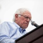 Vetting Failure? Sanders Caught In Crossfire elderly man speaking at a podium with a microphone
