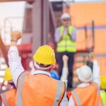 Unpaid Obama Project Sparks Union Layoffs construction workers raising fists during a safety briefing