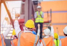 Unpaid Obama Project Sparks Union Layoffs construction workers raising fists during a safety briefing