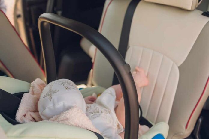 Newborn,Baby,Sleeping,In,The,Car,Seat Single candle burning among many on wooden surface.