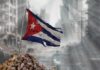 Soviet-Era Grid Crashes—Havana Goes Dark Again Worn Cuban flag standing on rubble in a desolate urban environment