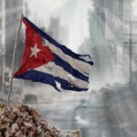 Soviet-Era Grid Crashes—Havana Goes Dark Again Worn Cuban flag standing on rubble in a desolate urban environment