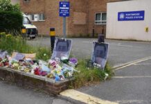Racism Lie Flips Script—Victim Treated As Thug Three police officers in high-visibility jackets stand facing a busy street