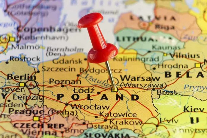 Red pushpin marking Poland on a European map