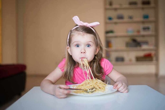 Girl eating spaghetti at a table