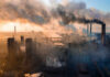 Baltimore’s Biggest Polluter Gets Subsidies Industrial facility with smoking chimneys under a colorful sky