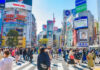 Crowded Shibuya crossing with colorful advertisements buildings