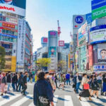Crowded Shibuya crossing with colorful advertisements buildings