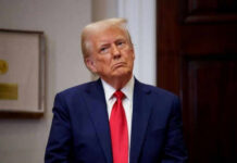 Person in suit and red tie standing indoors