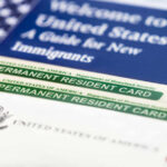 DHS Rewrites ‘Public Charge’—Chaos Ahead U.S. permanent resident cards with immigration guide and flag