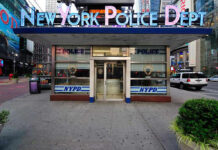 NYPD Milestone Fuels Trump–Hochul Showdown NYPD precinct building with signs on a city street