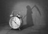 alarm clock with grim reaper shadow