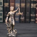 Appeals Bench Yanks Judge To Calm Outrage Lady Justice statue with scales in front of law books
