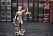 Appeals Bench Yanks Judge To Calm Outrage Lady Justice statue with scales in front of law books
