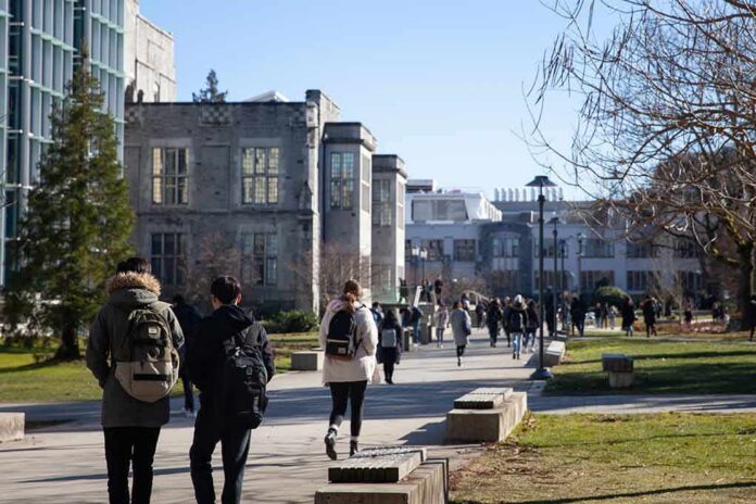 shutterstock_1323816485 students walking on a university campus pathway