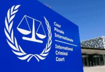 International Criminal Court sign with scales emblem outside modern building