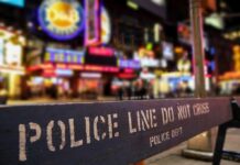 Police barrier with city nightlife in the background
