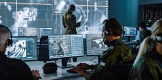 Military analysts at computers in a command center