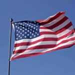 Arena Boos Ignite Reese Firestorm Waving American flag against a clear blue sky