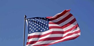 Waving American flag against a clear blue sky