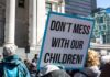 protest sign held in a crowd outside a government building