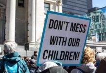 Parents Revolt: Pope Dragged Into Gender Fight protest sign held in a crowd outside a government building