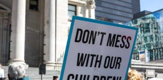 protest sign held in a crowd outside a government building