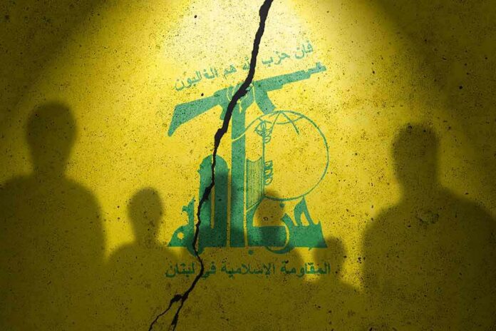 Hezbollah flag graphic with crack and silhouetted figures