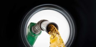 Fuel nozzle pouring gasoline into a tank
