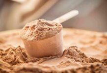 Whey Boom Hijacks Dairy — Farmers Squeezed Scoop of chocolate protein powder in a measuring cup