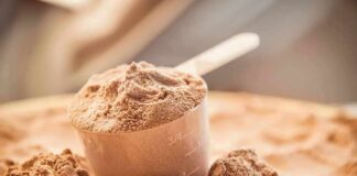 Scoop of chocolate protein powder in a measuring cup