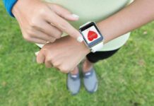 Person checking smartwatch heart rate on wrist outdoors
