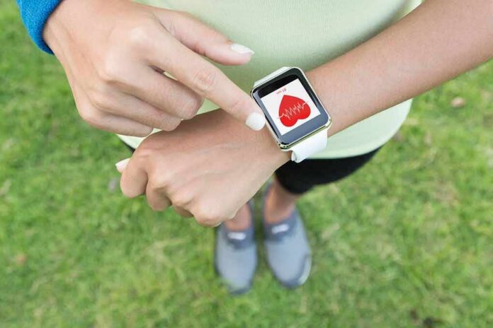 shutterstock_331486559 Person checking smartwatch heart rate on wrist outdoors